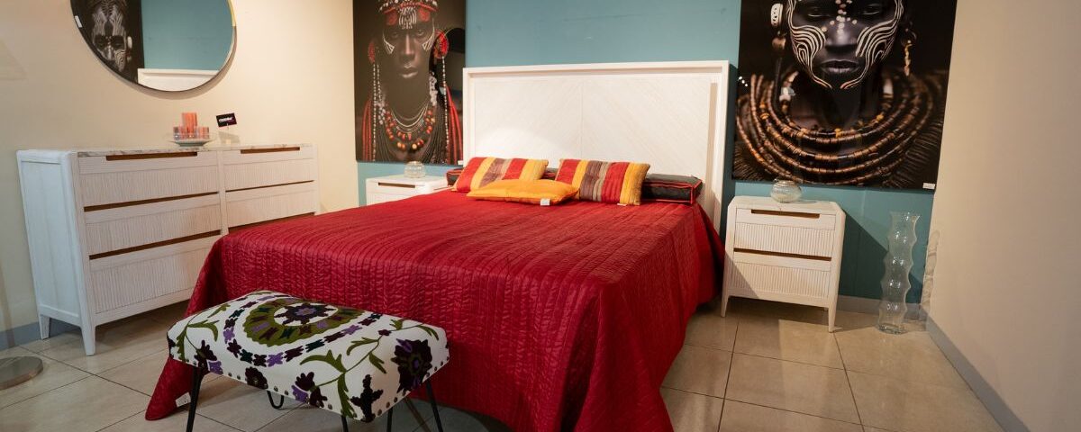 un dormitrio con una cama, un banco y muebles - mobilia