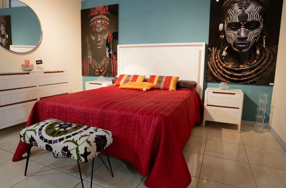 un dormitrio con una cama, un banco y muebles - mobilia