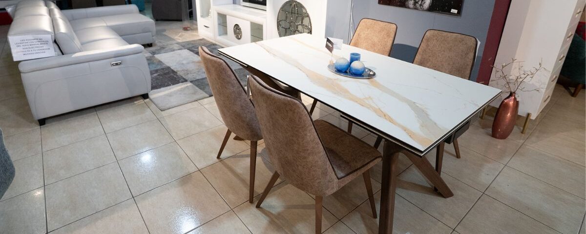 una mesa con sillas y sofá de fondo - mobilia